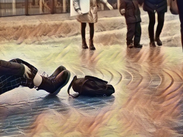 Ice crusted ground, paving slabs surface covered ice, slippery street, winter weather. Slipped girl lying on the sidewalk