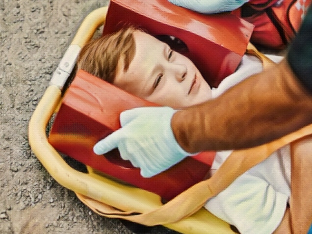 Young injured boy lying on an ambulance stretcher