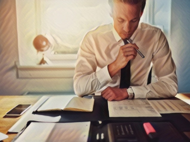 Serious business man working on documents looking concentrated with briefcase and phone on the table. Concept of SSA Work Classifications