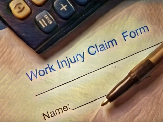 work injury claim form with calculator and pen on top