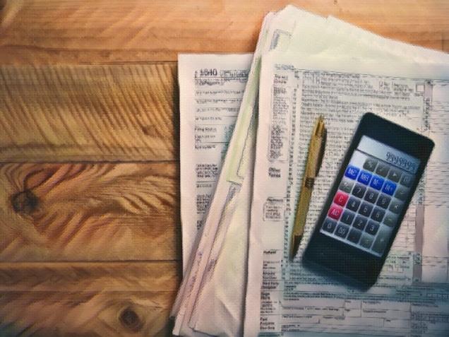 Filling 1040 tax form with smartphone calculator and pen