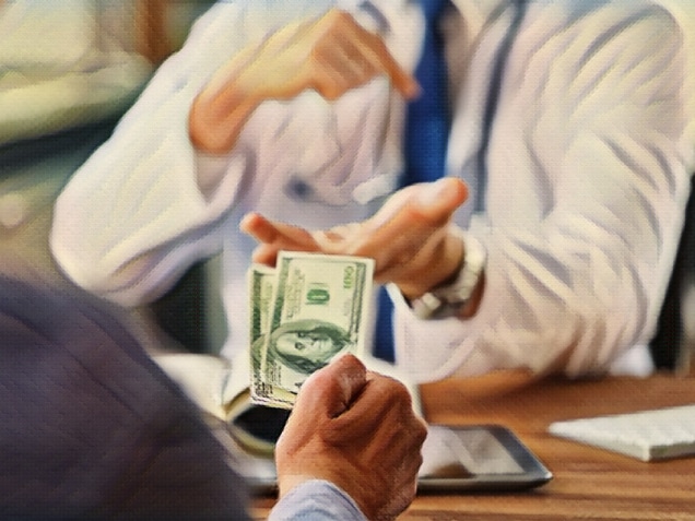 Patient giving money to medical doctor in hospital setting