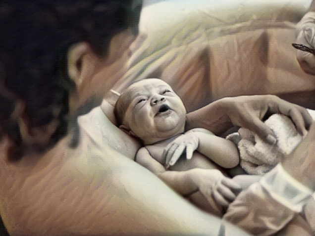 Newborn baby immediately after a home birth in pool. Looking up at mother.