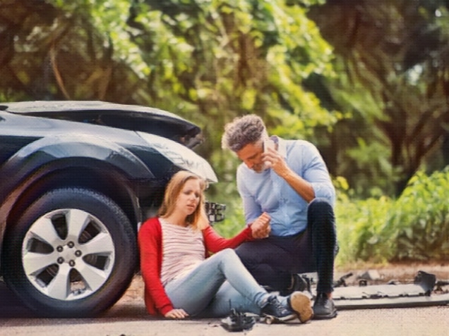 Young woman by the car after an accident and a man with smartphone