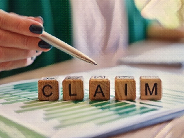 Woman pointing with pen on word claim made with wooden cubes in row