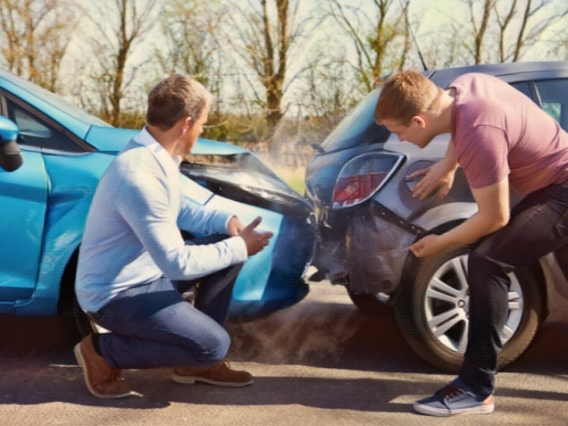 Two Drivers Arguing After Traffic Accident looking at damage