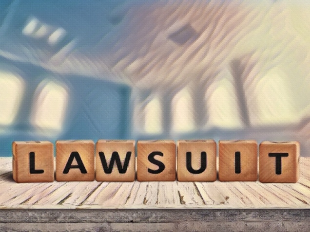 Lawsuit sign on a wooden table in a blurry bright blue room