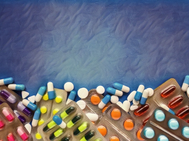 Assorted pharmaceutical medicine pills, tablets and capsules over blue background. Concept of 3 Types of Prescription Errors