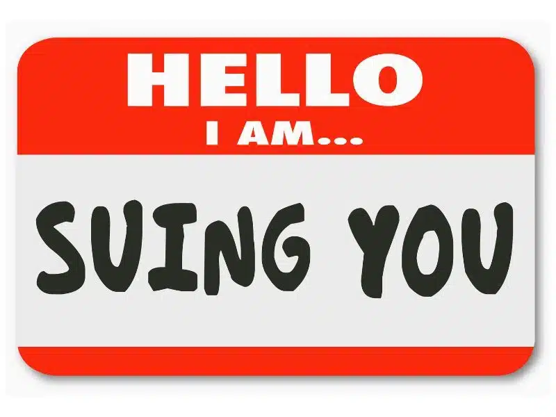 Hello I Am Suing You words on a name tag sticker informing that someone is bringing a lawsuit. Can I Sue the Insurance Company for Taking Too Long