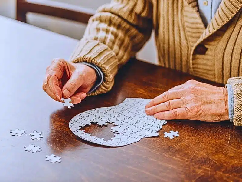 cropped view of senior man playing with puzzles. Is Mental Health Considered a Disability for LTD Benefits?