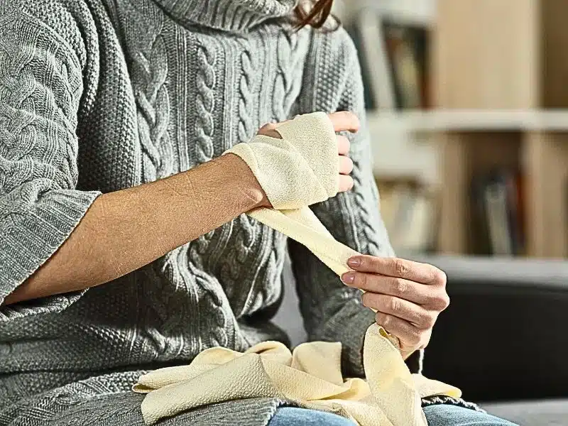 Injured woman hands removing bandage from arm. Reasons short term disability can be denied