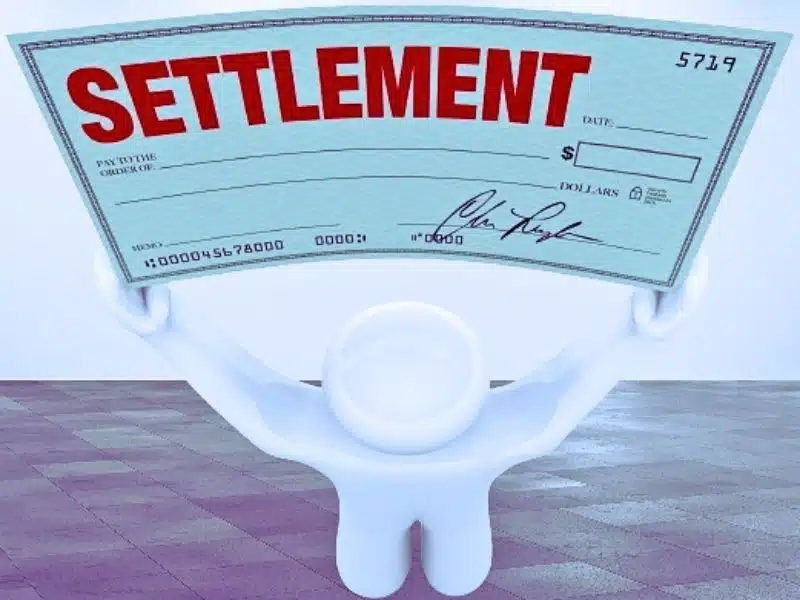 A man holds a large settlement check. What is the average settlement for mesothelioma victims?