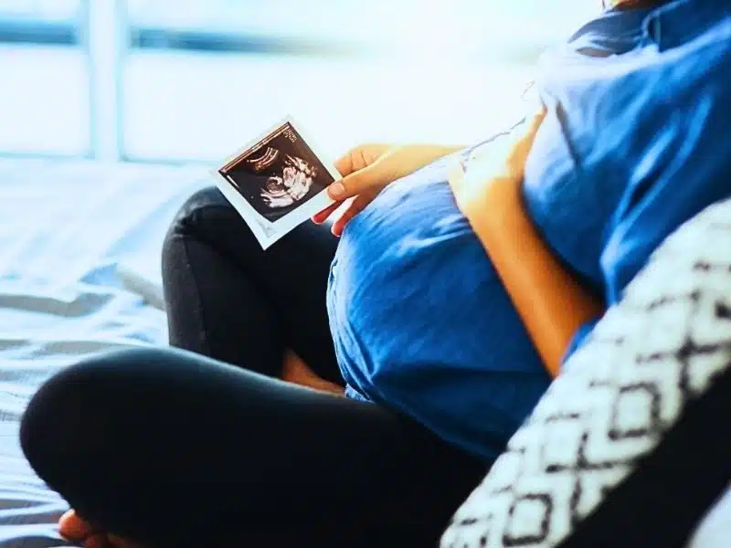 Closeup shot of an unrecognizable pregnant woman holding an ultrasound scan. Insufficient prenatal care